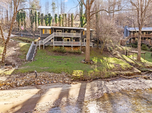 back of house featuring a yard and a water view