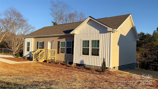 view of front of property featuring board and batten siding, crawl space, and a shingled roof