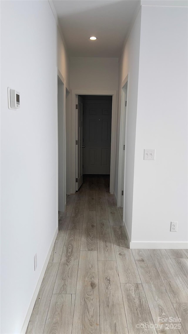 hall with recessed lighting, light wood-style flooring, and baseboards