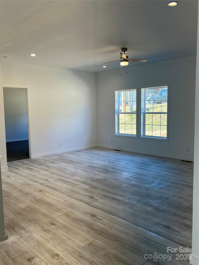 spare room with a ceiling fan, recessed lighting, baseboards, and wood finished floors