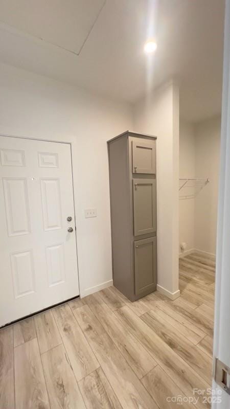 interior space featuring light wood-type flooring and baseboards