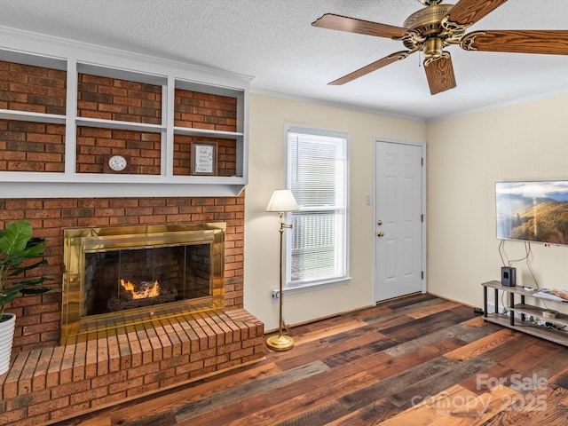 unfurnished living room featuring a brick fireplace, crown molding, dark hardwood / wood-style floors, and a textured ceiling