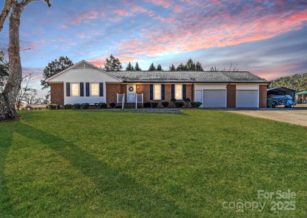 ranch-style house featuring a garage and a lawn