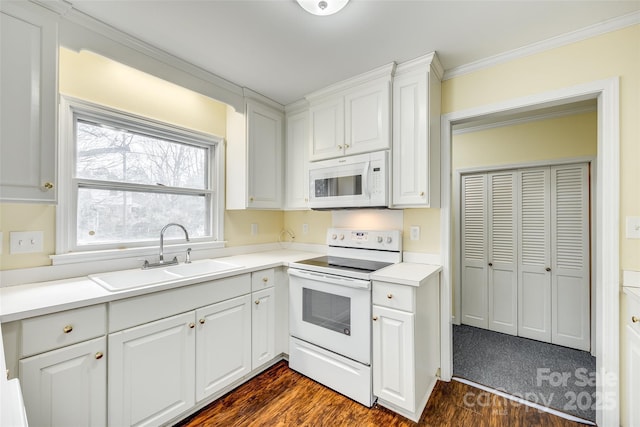 kitchen featuring sink, crown molding, white appliances, dark hardwood / wood-style floors, and white cabinets