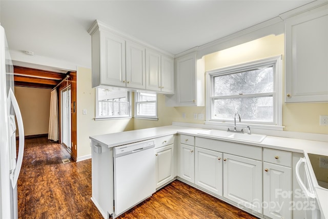 kitchen featuring white cabinetry, white appliances, kitchen peninsula, and sink