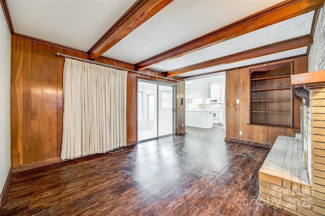 unfurnished living room with wooden walls, ornamental molding, dark hardwood / wood-style floors, and beamed ceiling