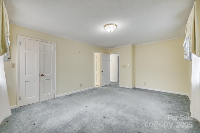 spare room with light carpet, crown molding, and a textured ceiling