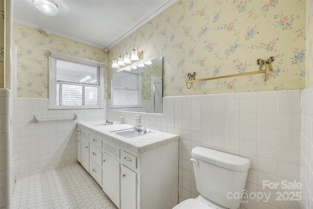 bathroom featuring tile walls, vanity, ornamental molding, and toilet