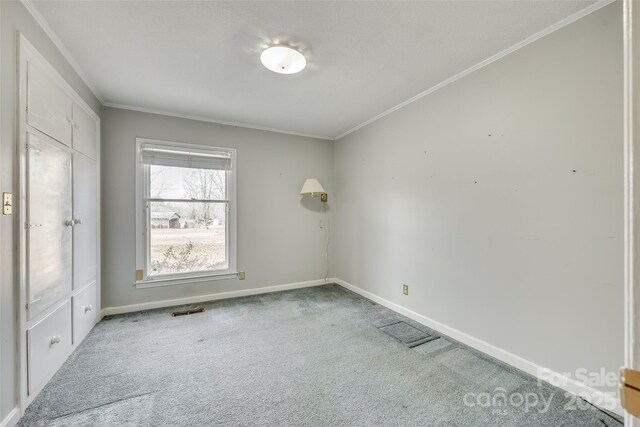 unfurnished room featuring carpet floors and ornamental molding