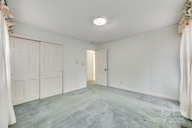 unfurnished bedroom with light carpet and a closet