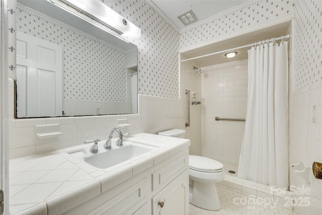 bathroom featuring tile walls, curtained shower, crown molding, and toilet