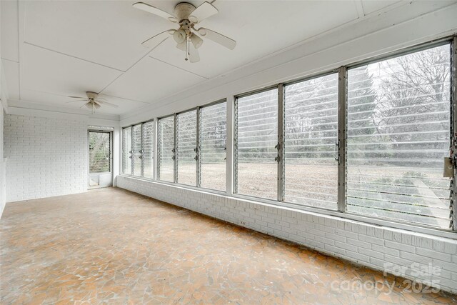 unfurnished sunroom featuring ceiling fan