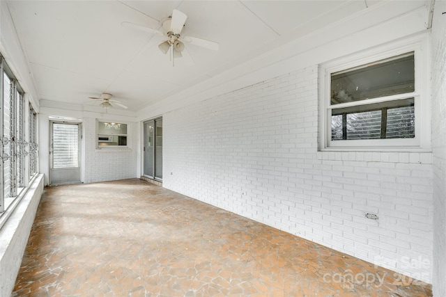 unfurnished sunroom featuring ceiling fan