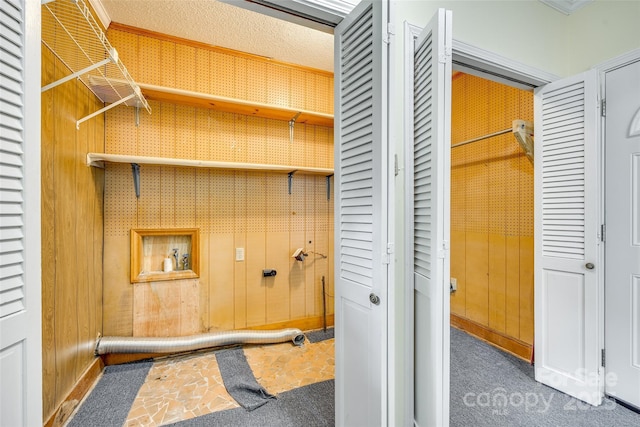 washroom featuring washer hookup, dark carpet, and wood walls