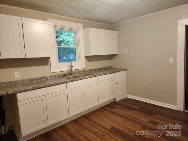 kitchen featuring sink, white cabinets, dark hardwood / wood-style flooring, and ornamental molding