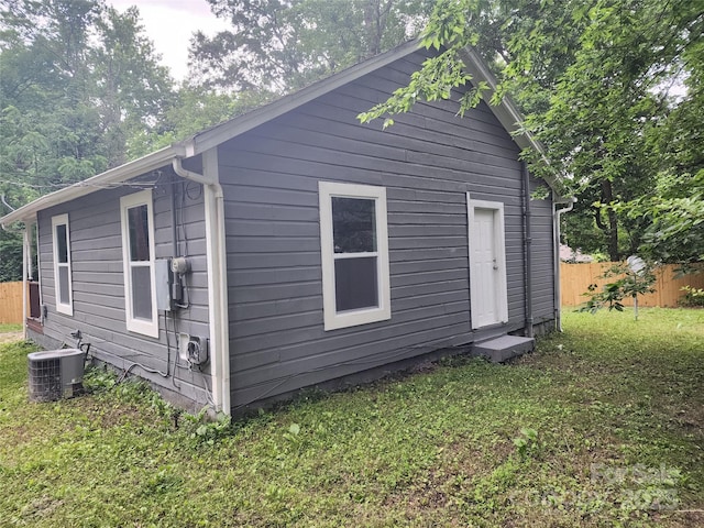 exterior space featuring cooling unit and a lawn