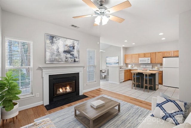 living room featuring ceiling fan and light hardwood / wood-style flooring