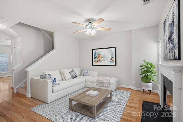 living room featuring light hardwood / wood-style floors and ceiling fan