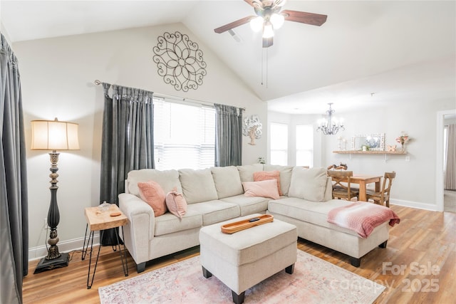 living room with ceiling fan with notable chandelier, plenty of natural light, wood-type flooring, and lofted ceiling