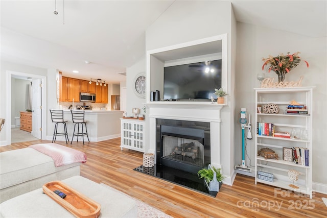 living room with light hardwood / wood-style flooring and lofted ceiling