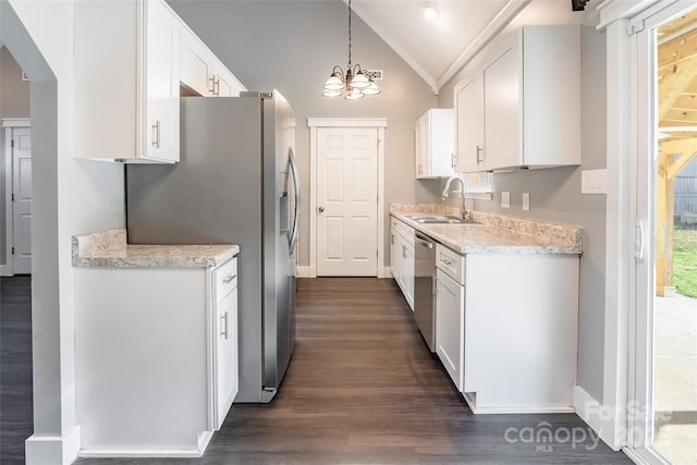 kitchen featuring white cabinets, lofted ceiling, stainless steel appliances, sink, and hanging light fixtures