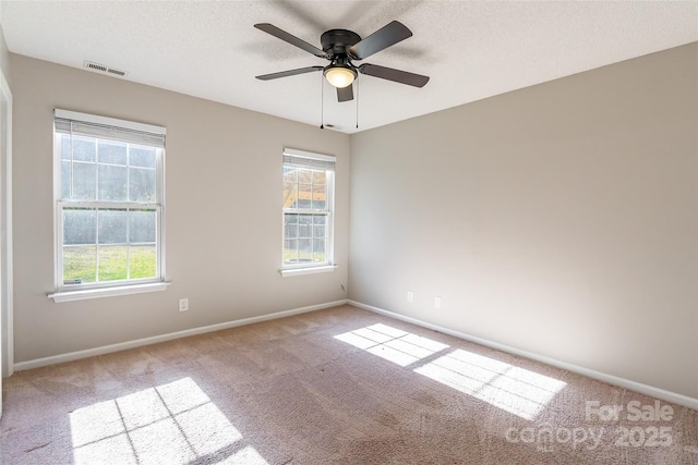 carpeted empty room with ceiling fan and a textured ceiling