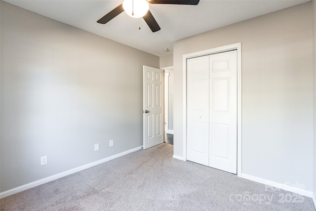 unfurnished bedroom featuring ceiling fan, a closet, and light colored carpet