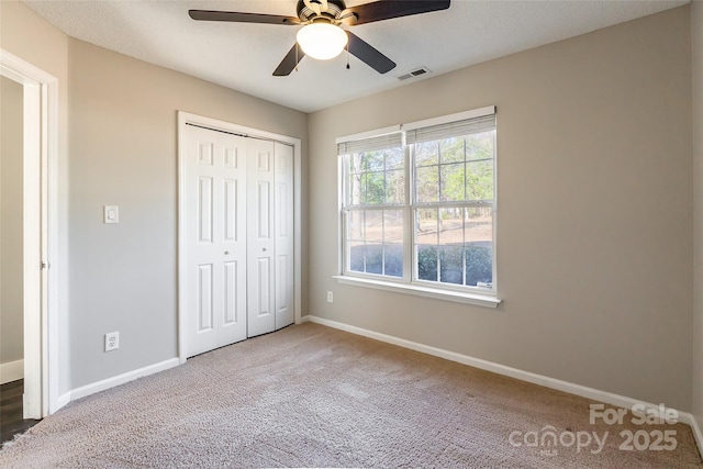 unfurnished bedroom featuring ceiling fan, a closet, and carpet floors