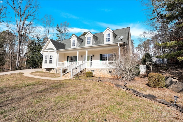 cape cod home featuring covered porch and a front lawn