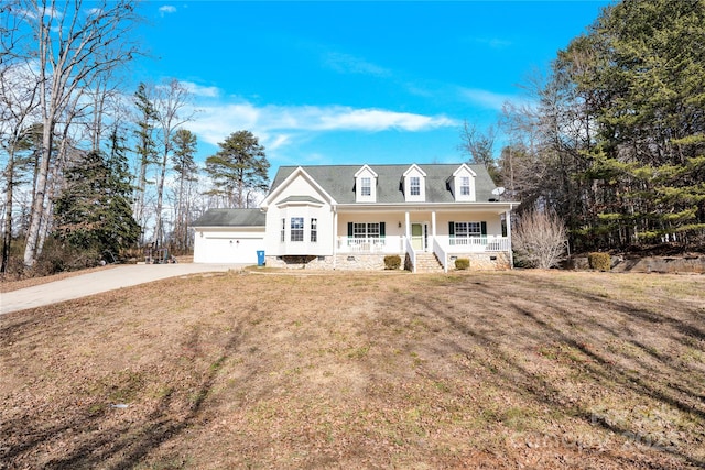 cape cod-style house featuring a garage, covered porch, and a front yard