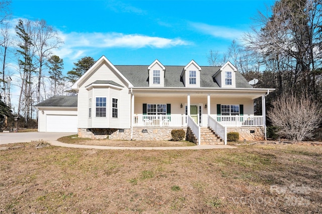 cape cod-style house featuring a porch, a garage, and a front yard