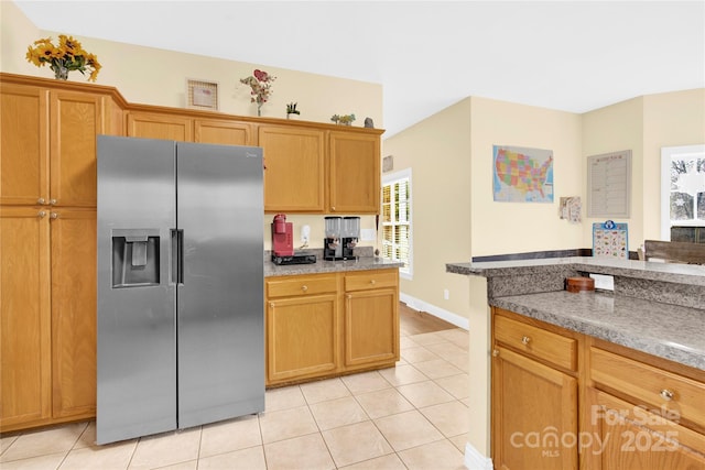 kitchen featuring light tile patterned flooring and stainless steel fridge