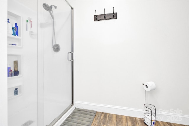 bathroom with hardwood / wood-style flooring and a shower with door