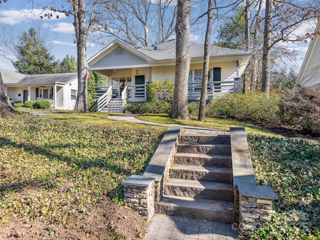 view of front of house with a front yard and covered porch