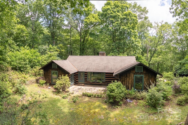 247 Skyuka Mountain Rd, Columbus, NC 28722 - view of front of property with a chimney, roof with shingles, and a view of trees