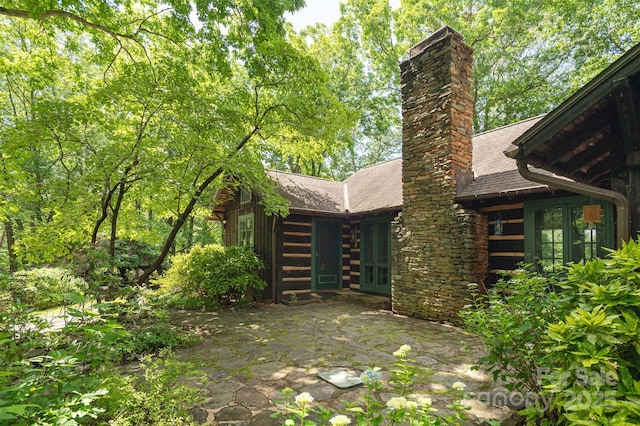 247 Skyuka Mountain Rd, Columbus, NC 28722 - view of side of property featuring roof with shingles, a chimney, and a patio area