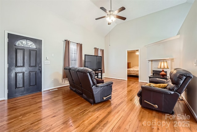 living room with ceiling fan, high vaulted ceiling, and hardwood / wood-style floors