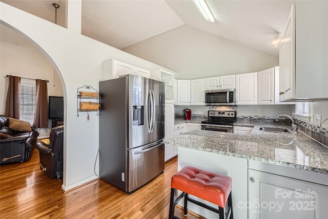 kitchen featuring sink, stainless steel appliances, white cabinetry, and stone countertops