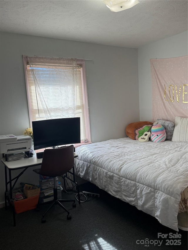 bedroom featuring a textured ceiling and carpet