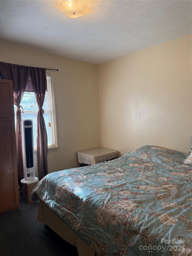 bedroom featuring a textured ceiling and carpet flooring