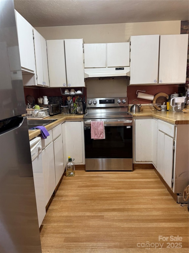 kitchen with light wood-type flooring, appliances with stainless steel finishes, a textured ceiling, and white cabinetry