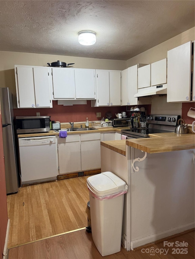 kitchen featuring kitchen peninsula, appliances with stainless steel finishes, and white cabinets