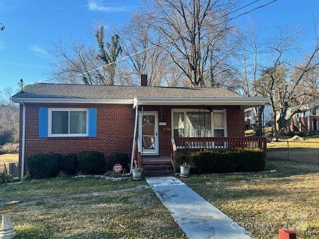 bungalow-style home with a front lawn and a porch