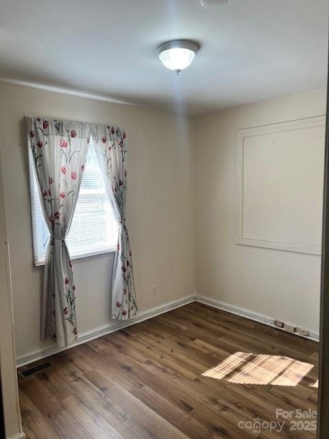 spare room featuring dark hardwood / wood-style floors