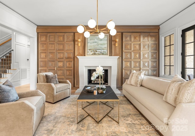 living room with an inviting chandelier and ornamental molding