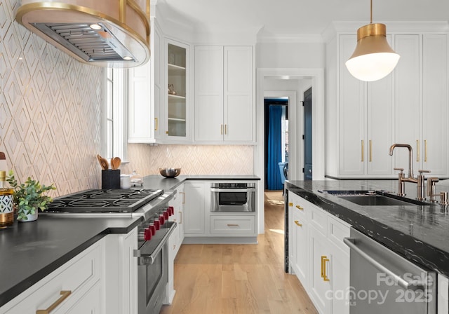 kitchen with pendant lighting, sink, white cabinetry, stainless steel appliances, and ventilation hood