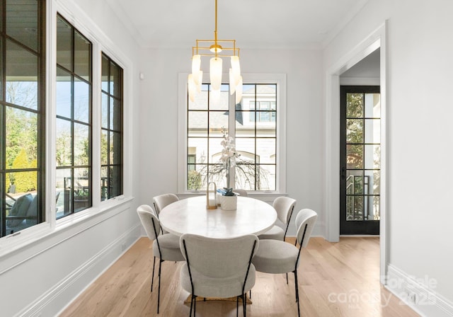 dining space featuring crown molding, a notable chandelier, and light hardwood / wood-style floors