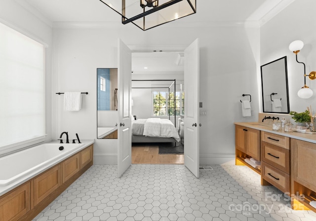 bathroom with crown molding, vanity, and a bathtub