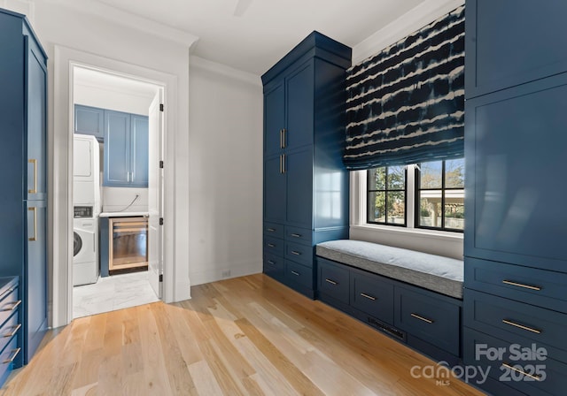 mudroom featuring stacked washer and clothes dryer and light hardwood / wood-style floors