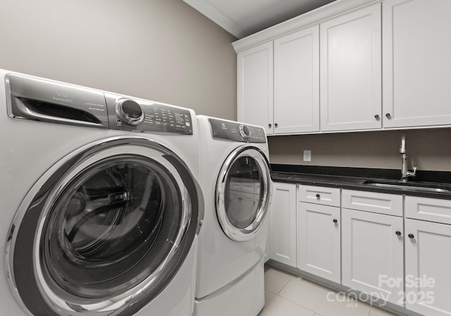 laundry room featuring cabinets, light tile patterned flooring, separate washer and dryer, and sink